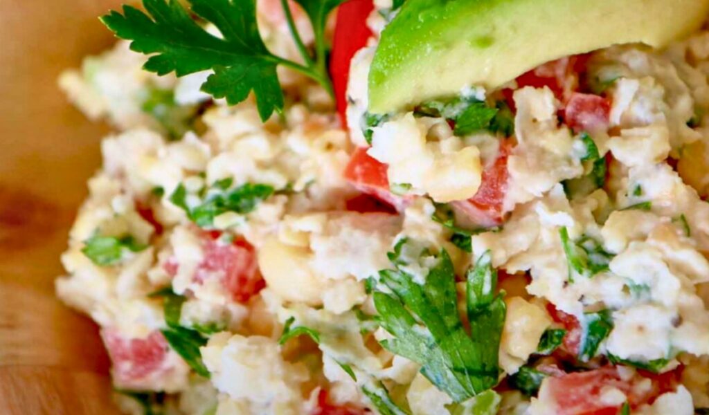 A close-up of chickpea salad with parsley and plant-based mayo.