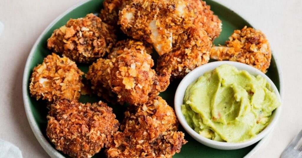 Crispy cauliflower wings served with a side of guacamole dipping sauce.