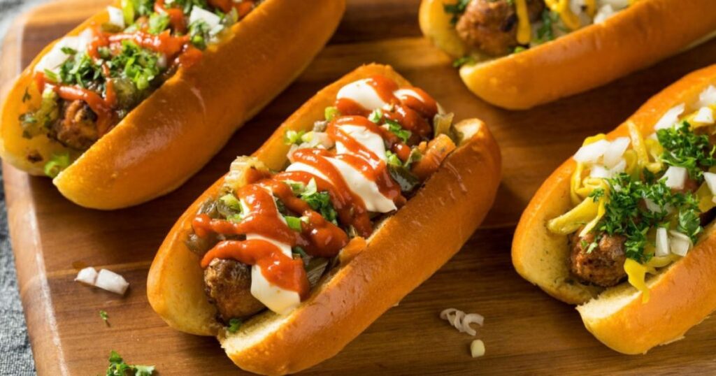 Plant-based sausages topped with condiments and served in a bun.